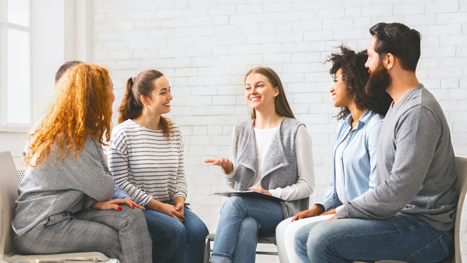 Therapist speaking to rehab group at therapy session, discussing problems and giving advices